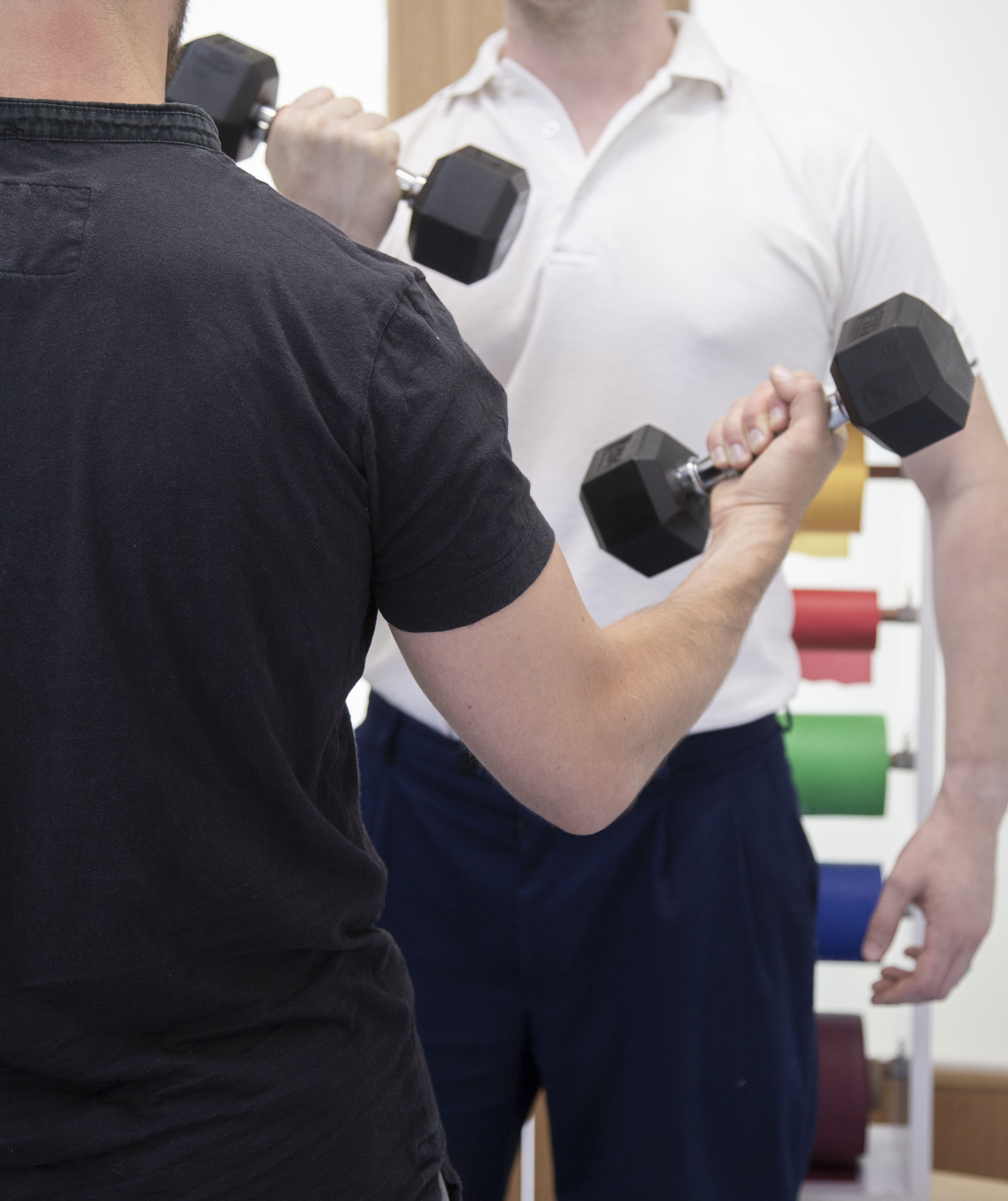 Physiotherapist demonstrating elbow excercises to patient with elbow pain.