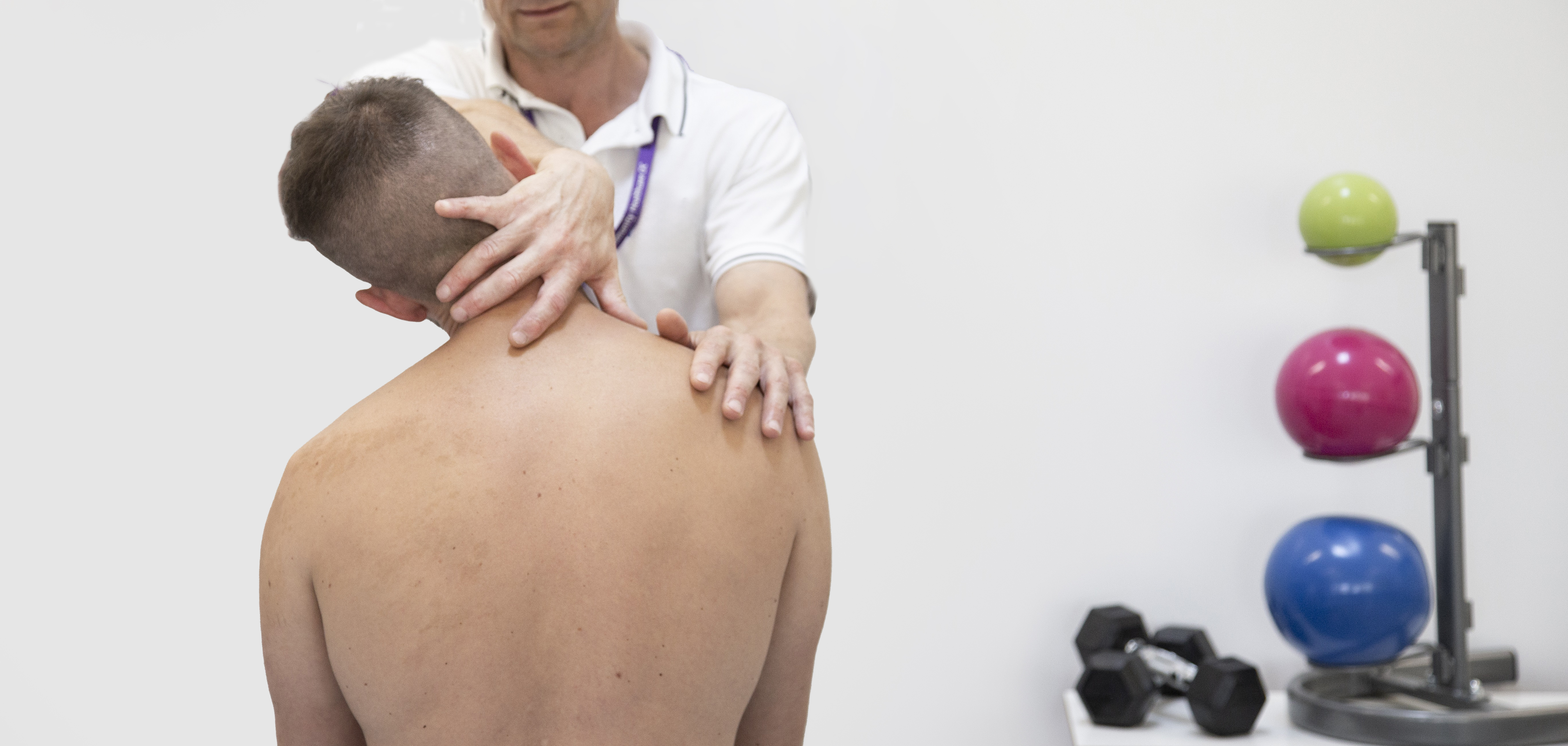 Physiotherapist performing exam on patient with neck pain or shoulder pain.